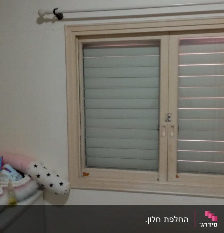 חלון עם תריסים סגורים במסגרת עץ